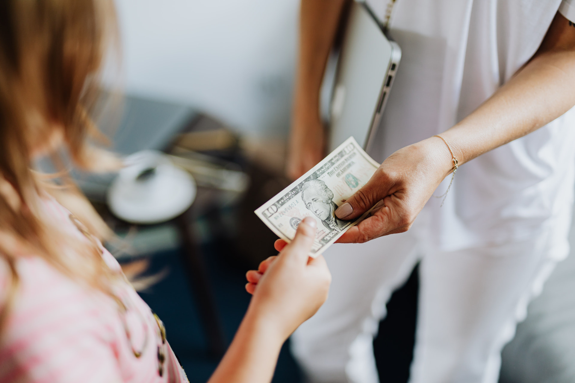 A teenager receiving cash from a parent